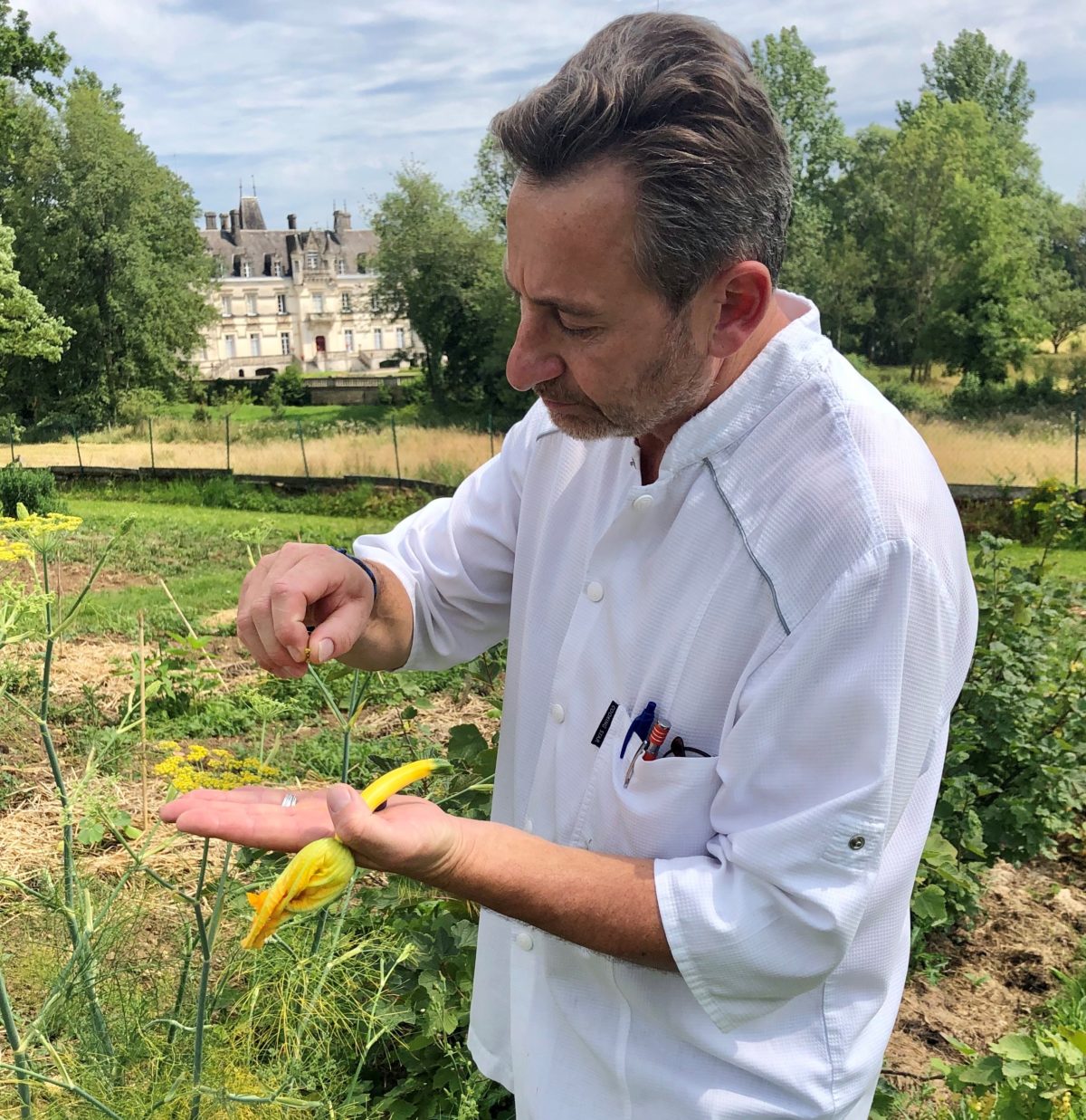 Pascal Pressac dans son potager avec le chateau de Nieuil au fond